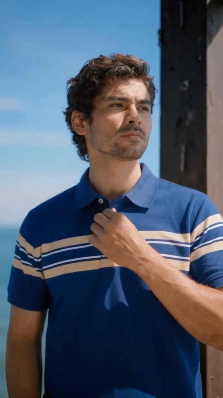 Man in a striped polo shirt by the sea